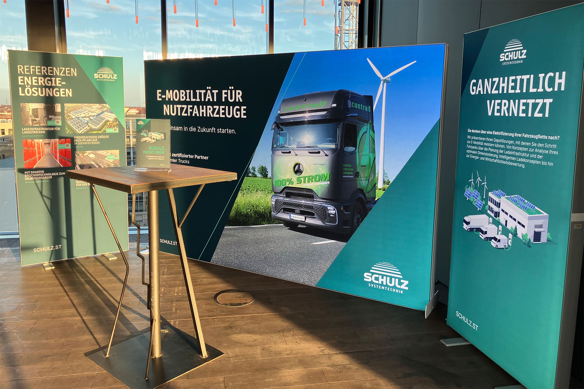 SCHULZ Messestand zu E-Mobilität und Energielösungen mit Informationsdisplays