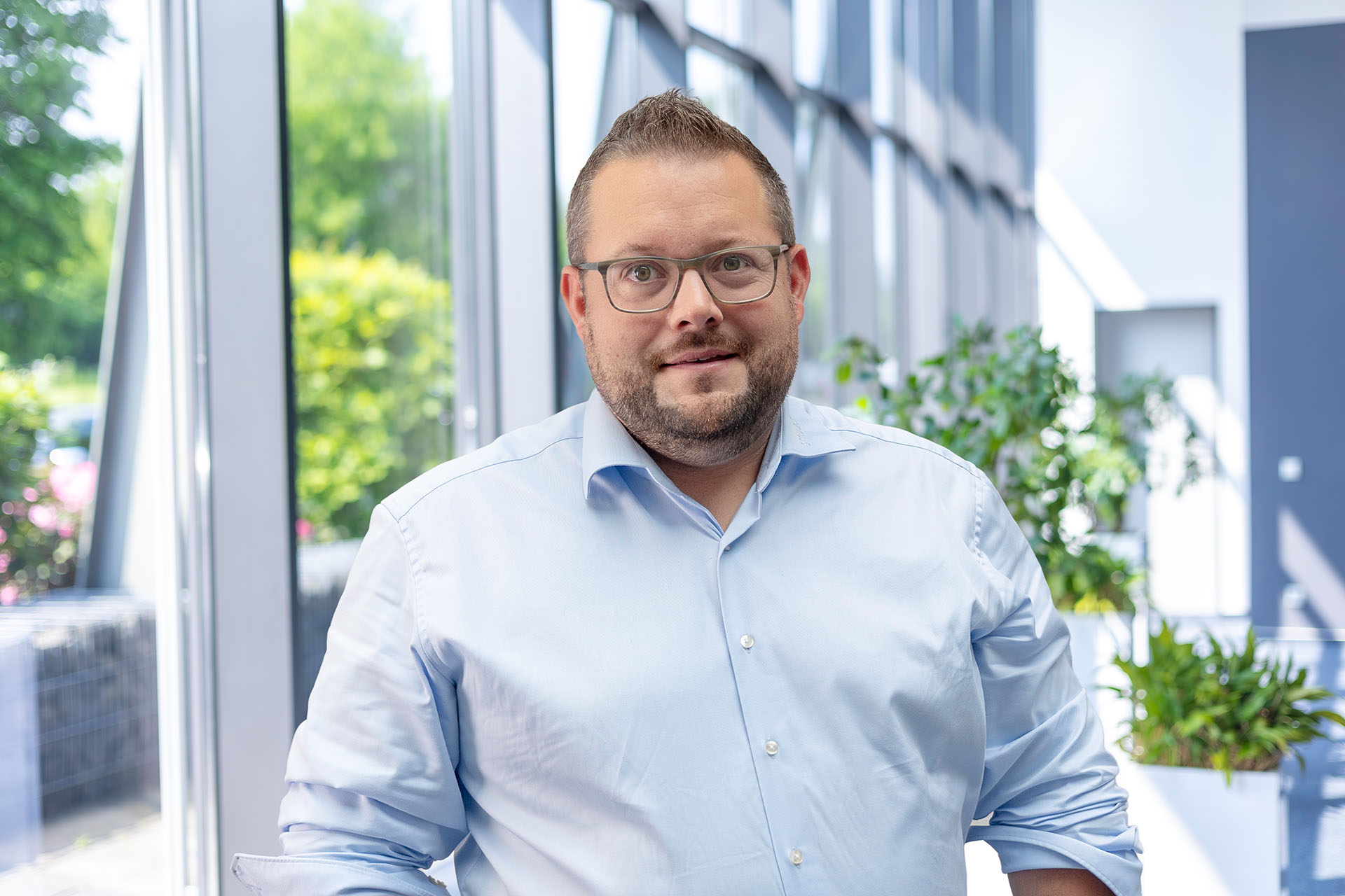 Benjamin Sternemann, Vertrieb Industrieautomation, vor einer Fensterfront.